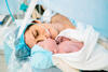 Neugeborenes wird nach Kaiserschnitt neben den Kopf der Mutter gelegt