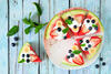Wassermelonen-Pizza belegt mit Naturjoghurt, Obststücken und Minze